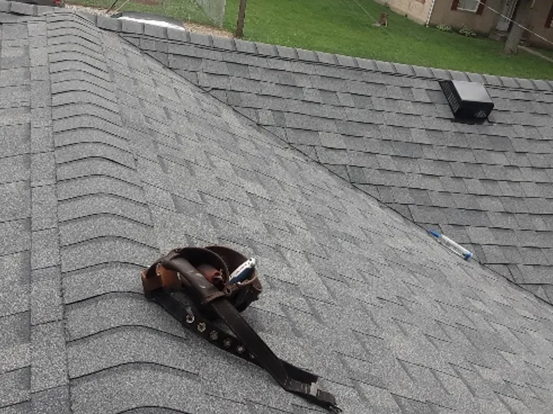 Rusted, failing pipe flashing on an aging shingle roof before repair