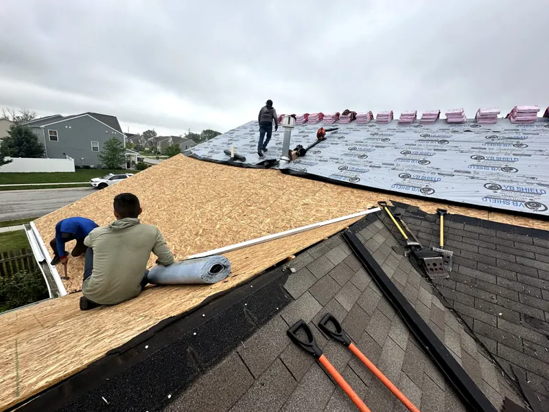 Crew installing new OSB roof decking on a subdivision home