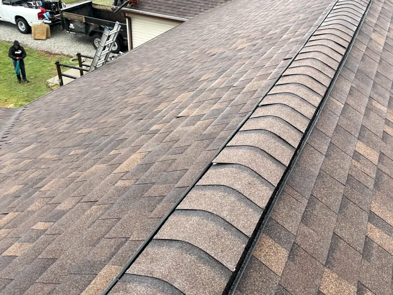 Close-up of driftwood-colored shingles and a straight ridge cap