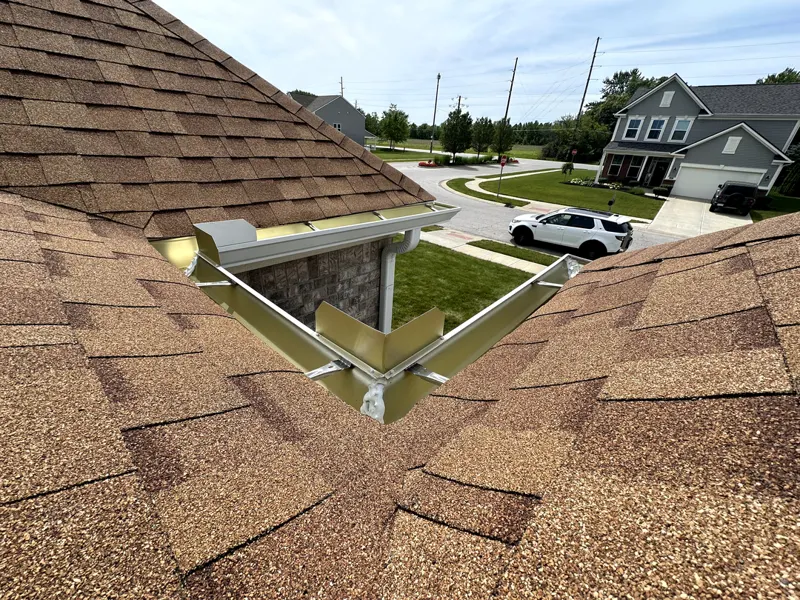 New gutter and valley detail on a brown shingle roof